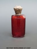 A Victorian ruby glass scent bottle with stopper and white metal screw top.