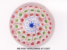An Old English patterned millefiori glass paperweight with central star shaped blue and white canes