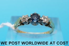 An 18ct gold ring set with a sapphire flanked by diamonds (size L)
