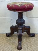 A revolving 19thC music stool with tripod base