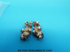 A pair of 9ct gold earrings set with diamonds and sapphires in a foliate design