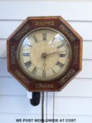 An octagonal brass inlaid pendulum wall clock