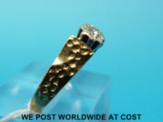 An 18ct gold ring with textured shoulders,
