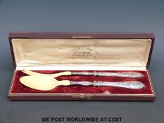 A cased pair of white metal and ivory Pavillon de Hanovre salad servers (length 28cm)