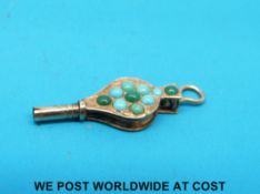 A yellow metal watch key in the form of bellows set with turquoise