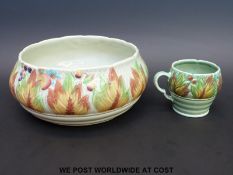 A Clarice Cliff leaf and berry fruit bowl (24cm diameter) together with a mug of the same design