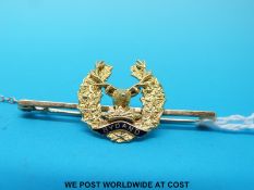 A yellow metal brooch depicting a deer and reading Bydand (Scottish regiment)