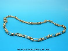 A yellow metal necklace made up of elongated links with chased decoration (19g)