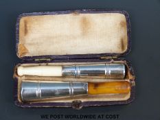 A cased pair of Dutch white metal mounted amber and ivory cheroot holders.