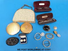 A Stratton bag containing two compacts with floral decoration,