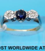 An 18ct gold ring set with a sapphire flanked by two diamonds,