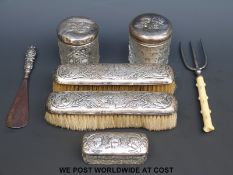 Three hallmarked silver dressing table pots with cherub decoration to the top and two hallmarked