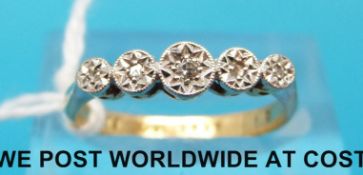 A yellow metal ring marked 18ct set with five diamonds in a platinum illusion setting,