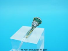 An 18ct gold ring set with an emerald cut emerald of approximately 1.