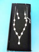 A silver necklace and earrings set with moonstones.