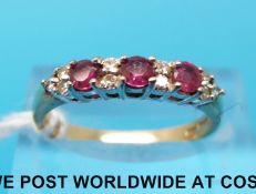 A 9ct gold ring set with alternating rubies and diamonds (size N)