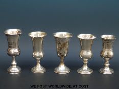 Four hallmarked silver goblets and a further example marked sterling (height of largest 14cm,