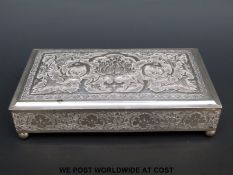 A possibly white metal cigarette box with embossed decoration depicting mythical creatures,