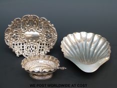 A hallmarked silver shell shaped butter dish raised on three ball feet together with a hallmarked