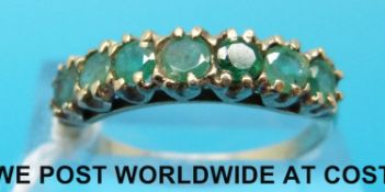 A yellow metal ring marked 9ct set with seven emeralds,