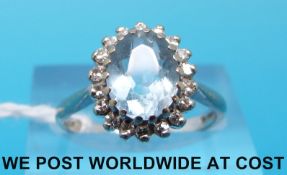 An 18ct white gold ring set with an aquamarine surrounded by diamonds (size L)