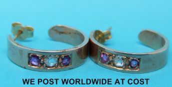 A pair of yellow metal earrings set with a diamond and two rubies to each