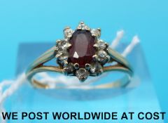 A 9ct gold ring set with a garnet surrounded by cubic zirconia (size O)