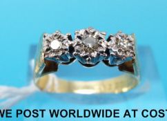 An 18ct gold ring set with three diamonds in an illusion setting (size O)
