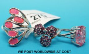 Three silver rings, one with crushed pink quartz,