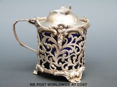 A Victorian hallmarked silver mustard pot with blue glass liner and leaf finial, London 1843,