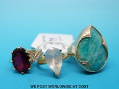 Three silver gilt rings one set with turquoise one topaz in a pear cut,