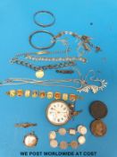 A tin containing costume jewellery to include silver bracelet, yellow metal brooch, two coins,