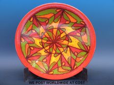 A large Poole signed pedestal shallow bowl with abstract design on a red ground (41cm diameter)