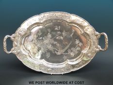 A Chinese silver two handled tray with relief and engraved decoration of birds in foliage raised on