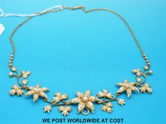 An Edwardian gold necklace set with seed pearls in multiple flower and leaf decoration, 40 cm long,