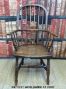 An antique child's stick back country Windsor carver chair with elm saddle seat