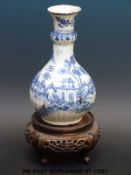 A 19thC Chinese vase with stapled repair on a period 19thC hardwood stand