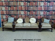 An Edwardian bergere suite comprising a three-seater settee and two chairs
