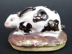 An 18th/19thC Staffordshire rabbit on base, 5.
