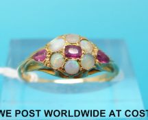 A yellow metal ring set with opals and rubies (size N)