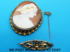 A cameo brooch depicting a classical figure, a yellow metal brooch and a yellow metal stick pin,