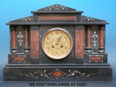 A two-train slate mantel clock inlaid with red marble Romanesque columned decoration and brass face,