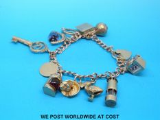 A 9ct gold charm bracelet with eleven 9ct/yellow metal charms including dog,
