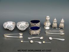 A pair of embossed hallmarked silver salts with blue glass liners,