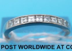 A white metal ring set with square cut diamonds (size P)