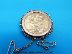 A yellow metal brooch set with a 1964 gold full sovereign (11.