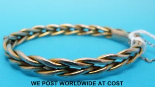 A 9ct gold bangle in a plaited design (8.