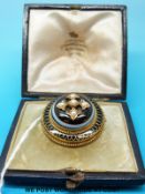A cased Victorian mourning brooch set with a banded agate cabochon and seed pearls surrounded by