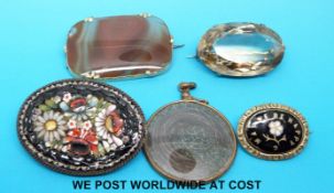 A yellow metal brooch set with agate, a white metal brooch set with a large oval quartz,