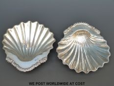 A pair of Goldsmiths & Silversmiths Co hallmarked silver shell dishes raised on ball feet,